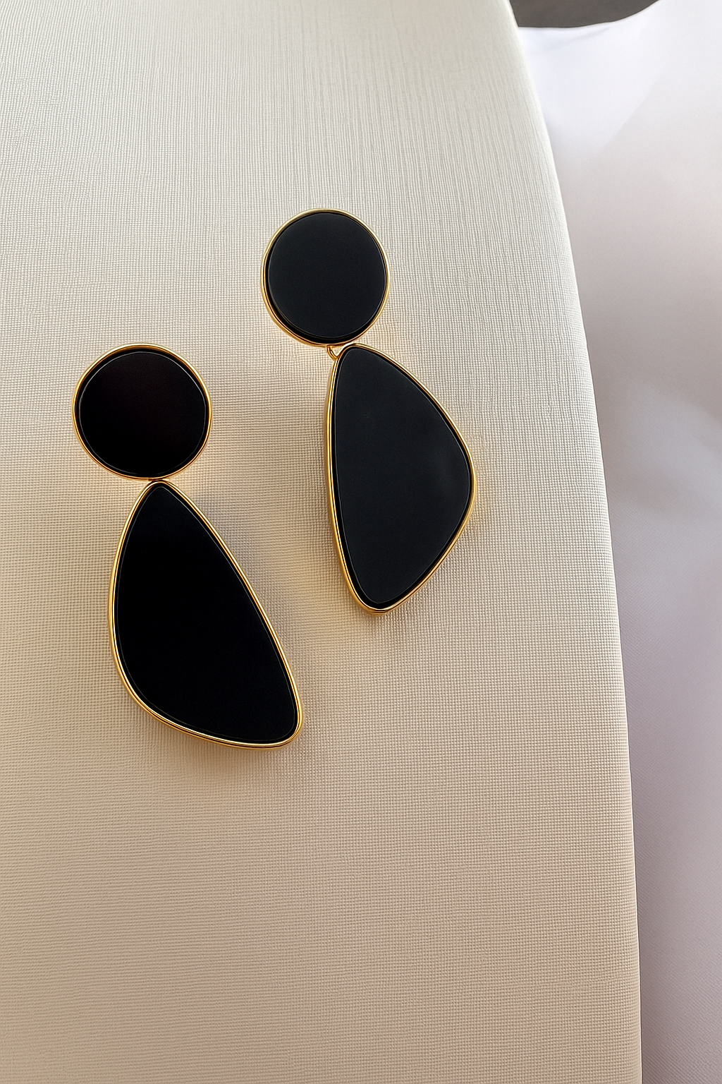Brinco geométrico preto com dourado.