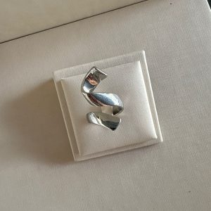 Anel escultural na cor prata.