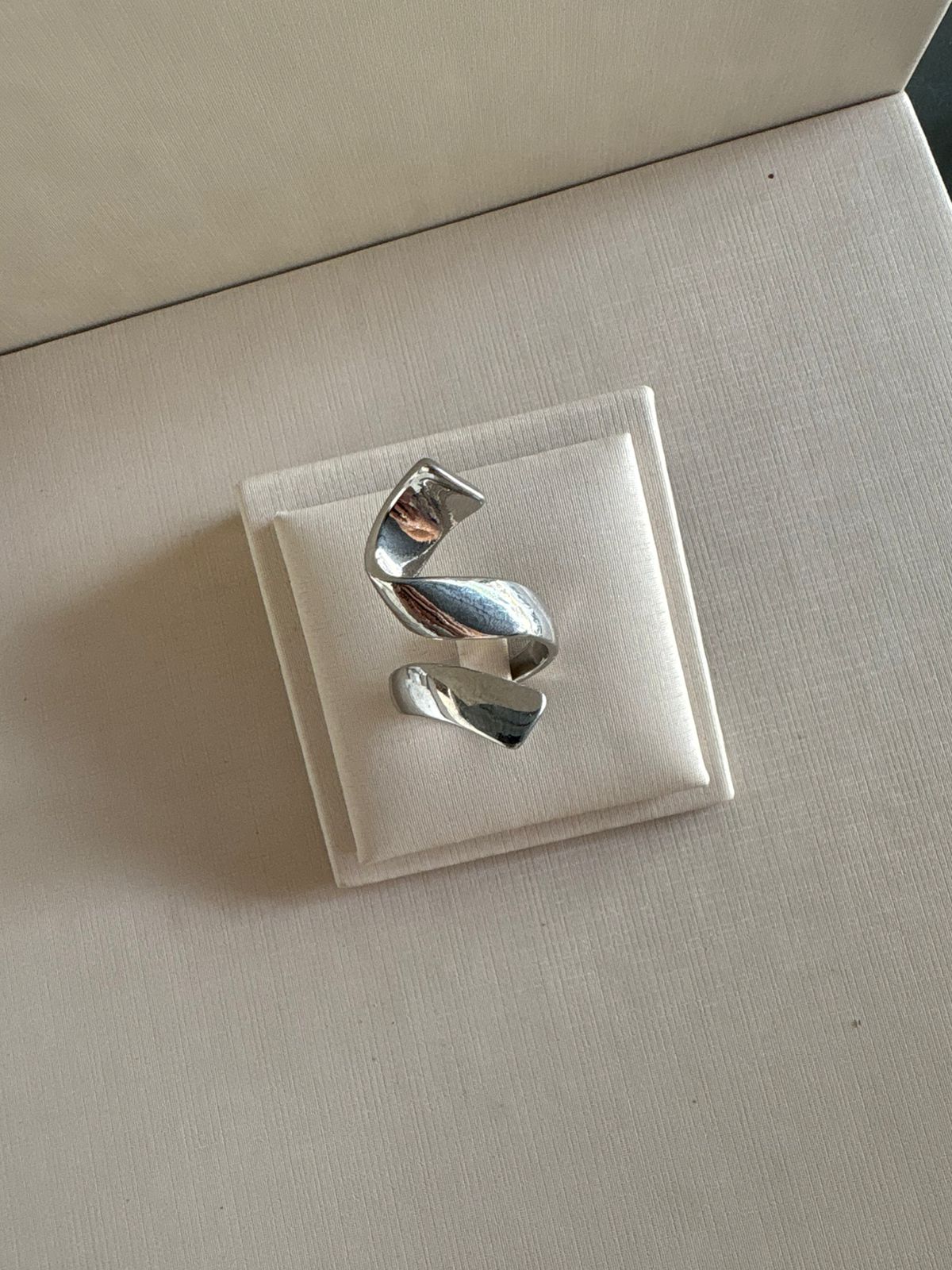 Anel escultural na cor prata.