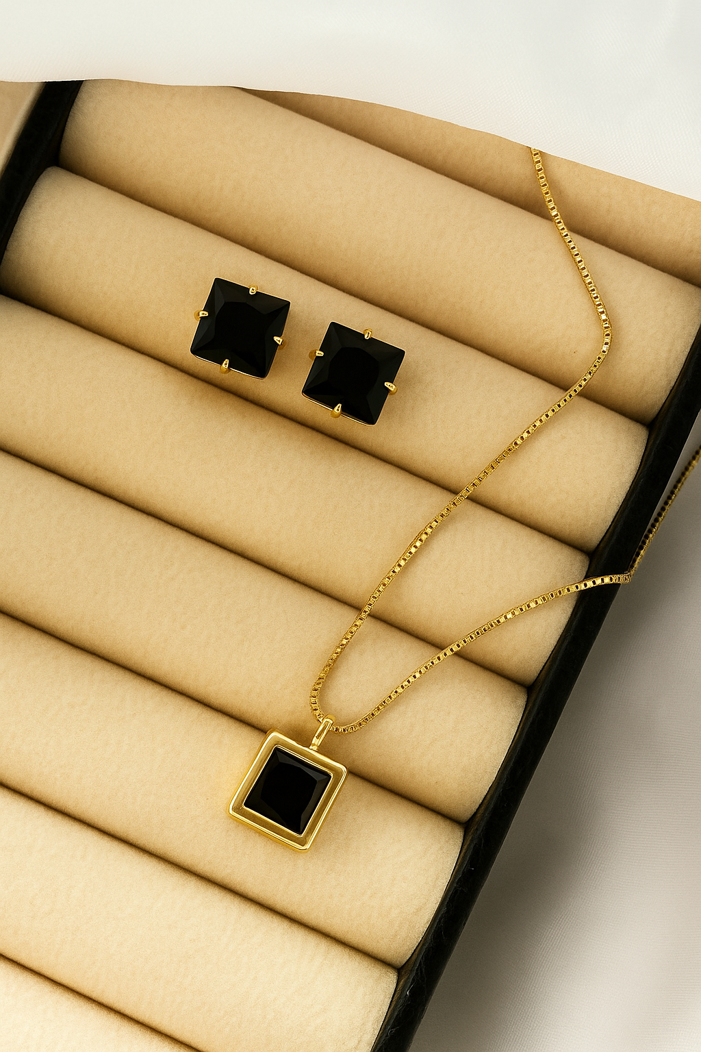 Conjunto composto por brincos e colar em banho dourado.