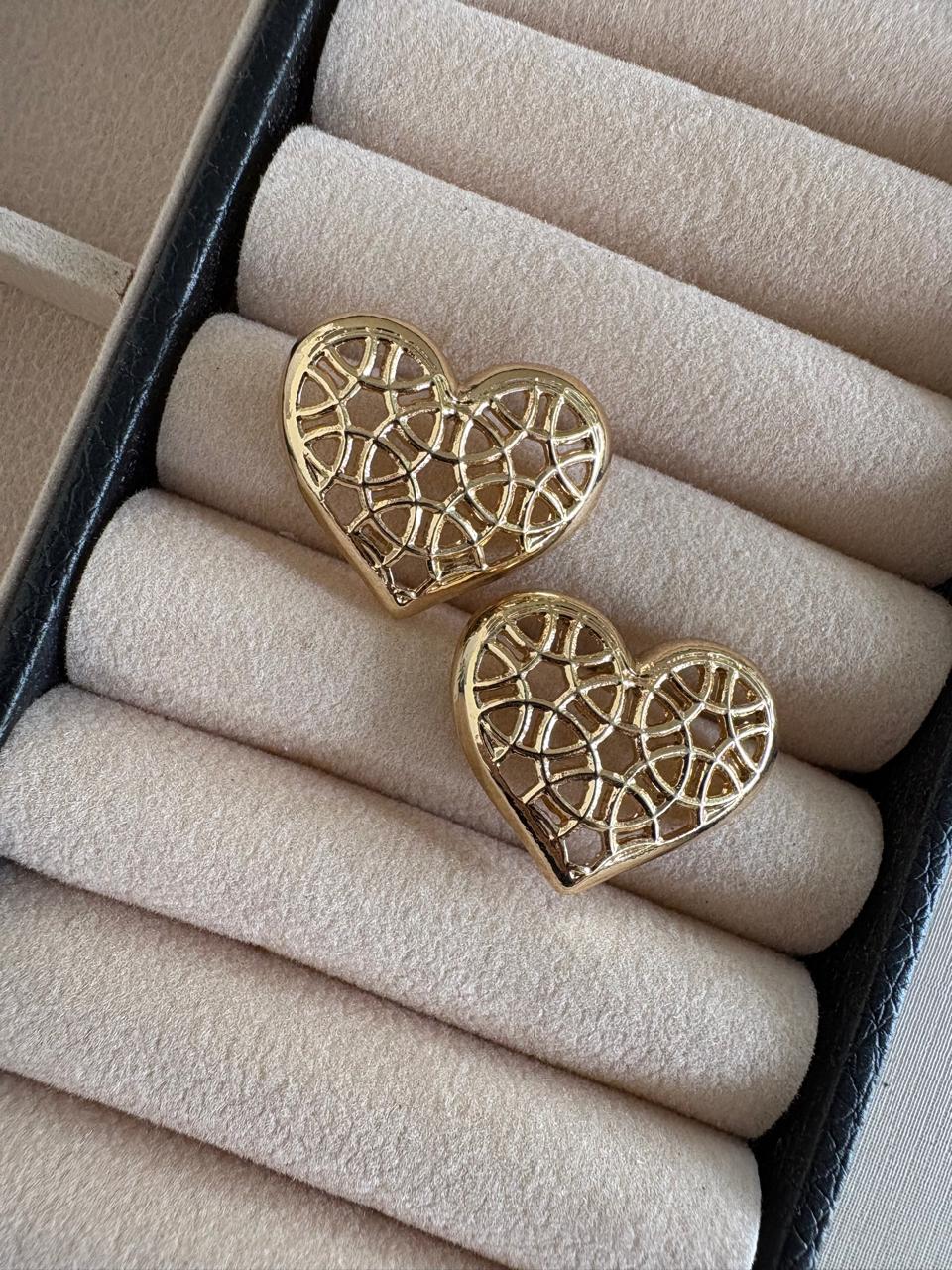 Brinco coração vazado na cor dourado.