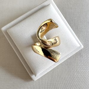 Anel escultural na cor dourado.