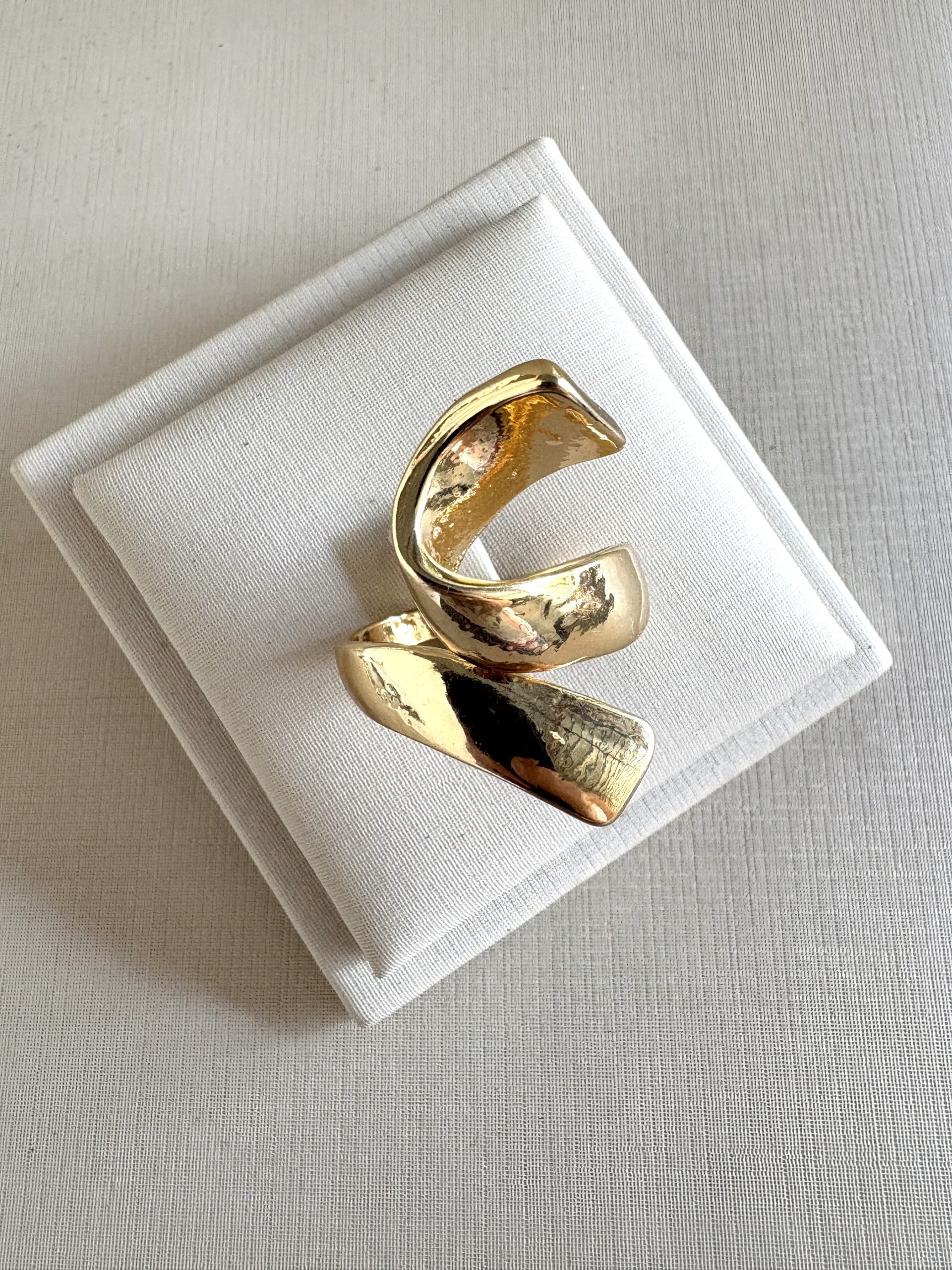 Anel escultural na cor dourado.