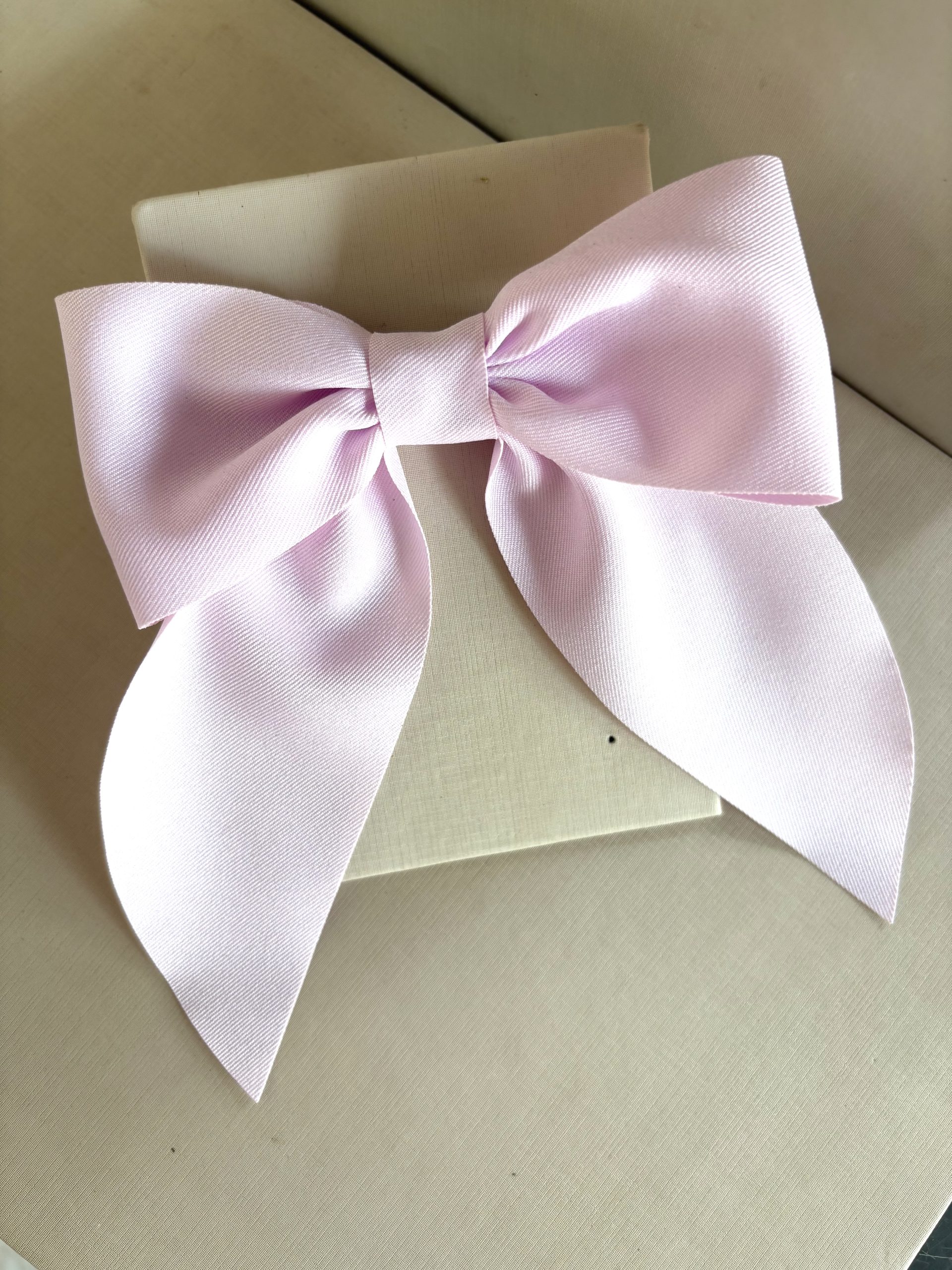 Laço em fita rosa claro.