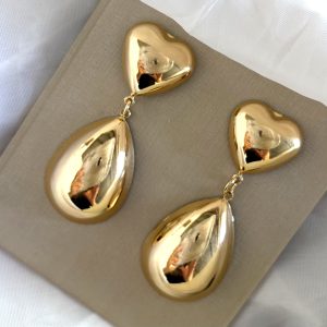 Brinco formato de coração na parte superior com uma gota alongada pendente.