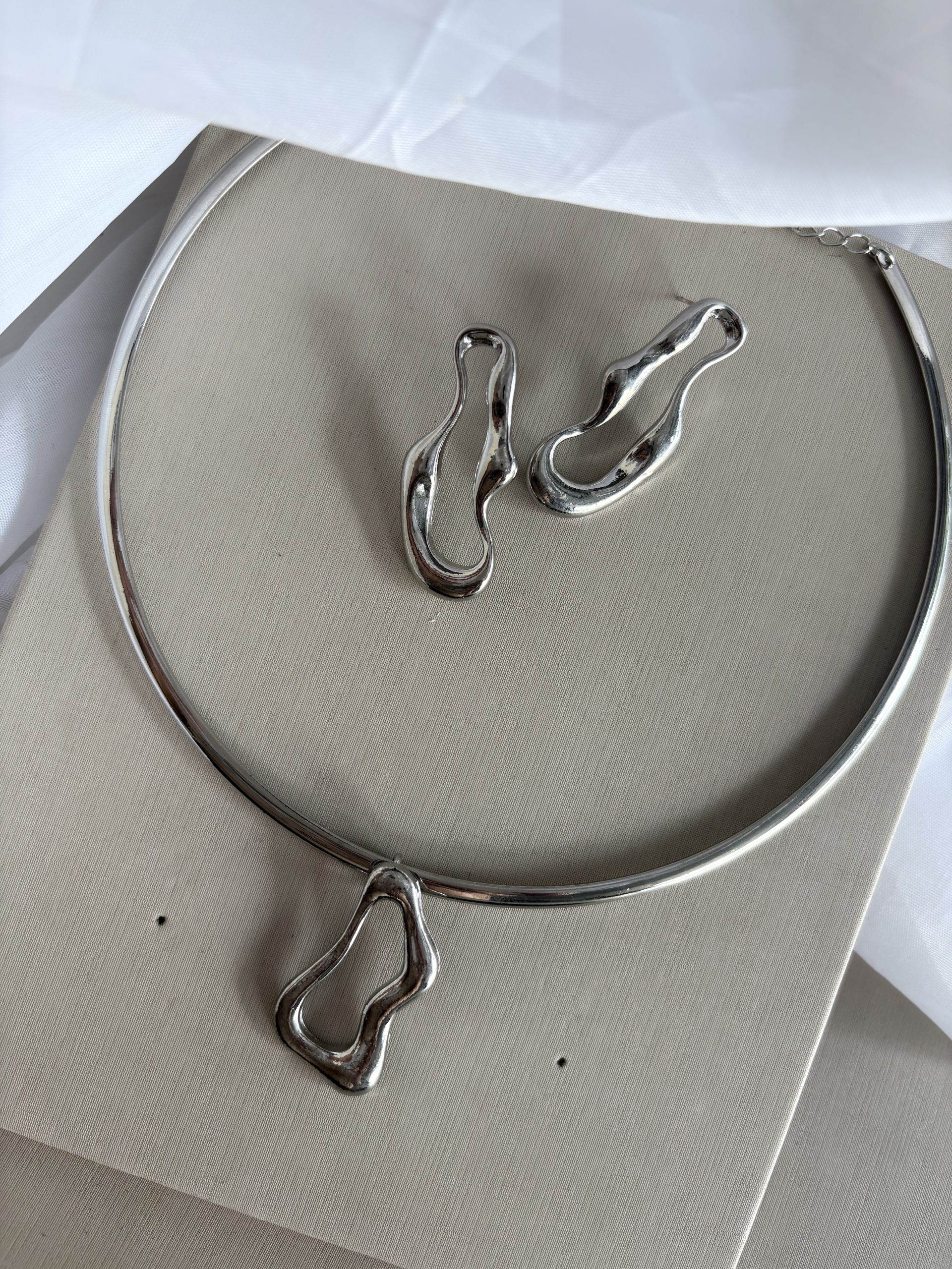 Conjunto na cor prata contorno orgânico.