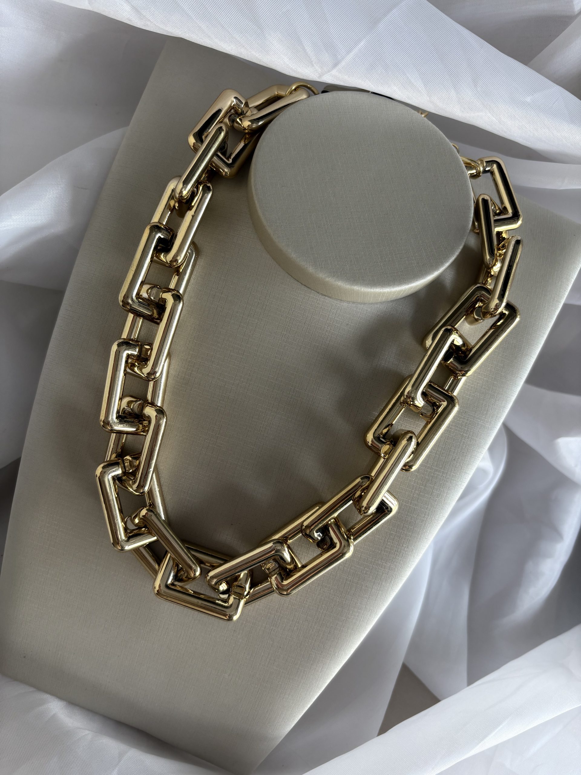 Colar dourado de elos geométricos.