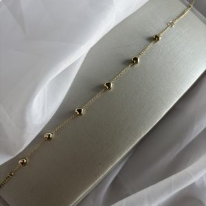 Choker dourada com coraçõezinhos delicados.