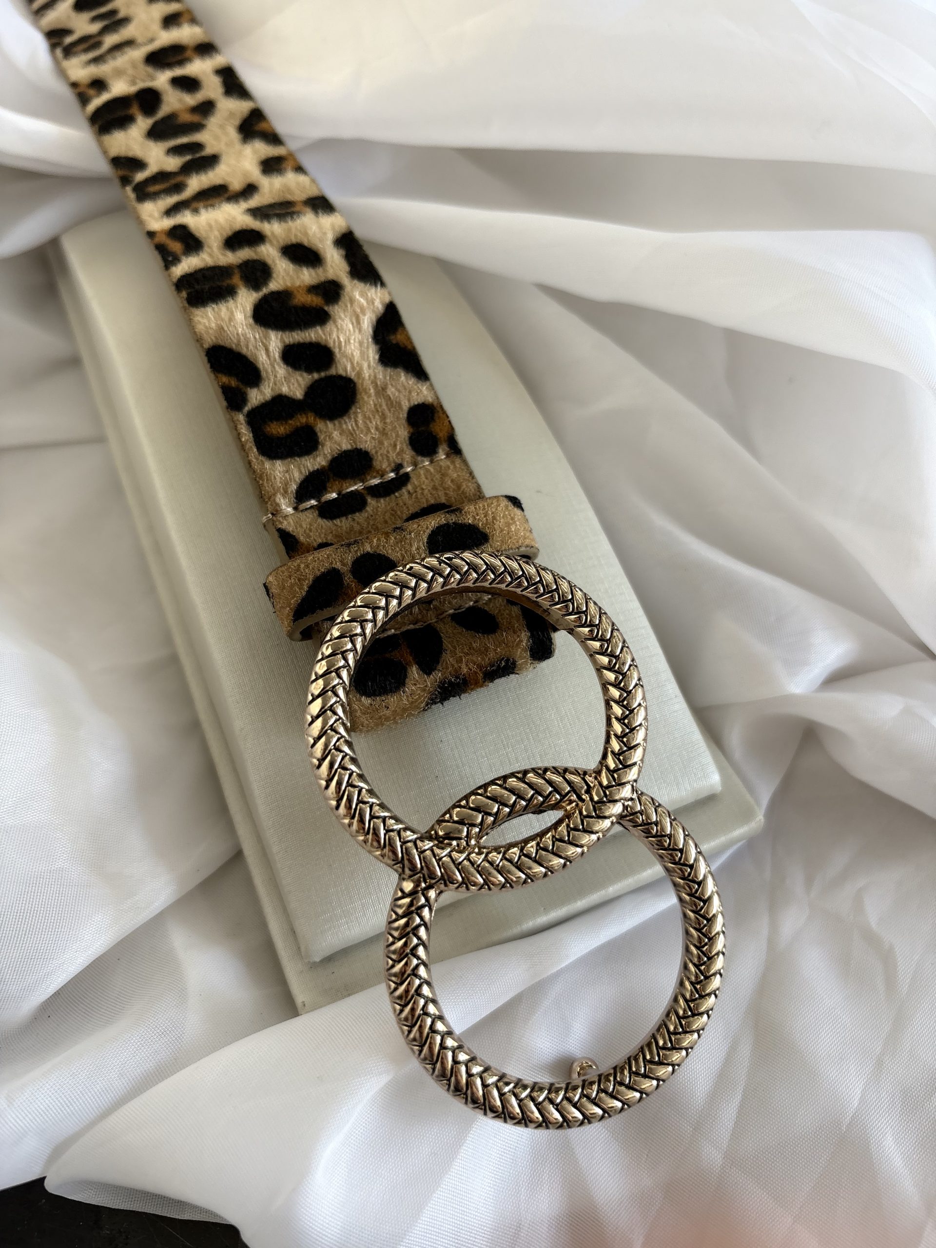 Cinto animal print com fivela dourada.