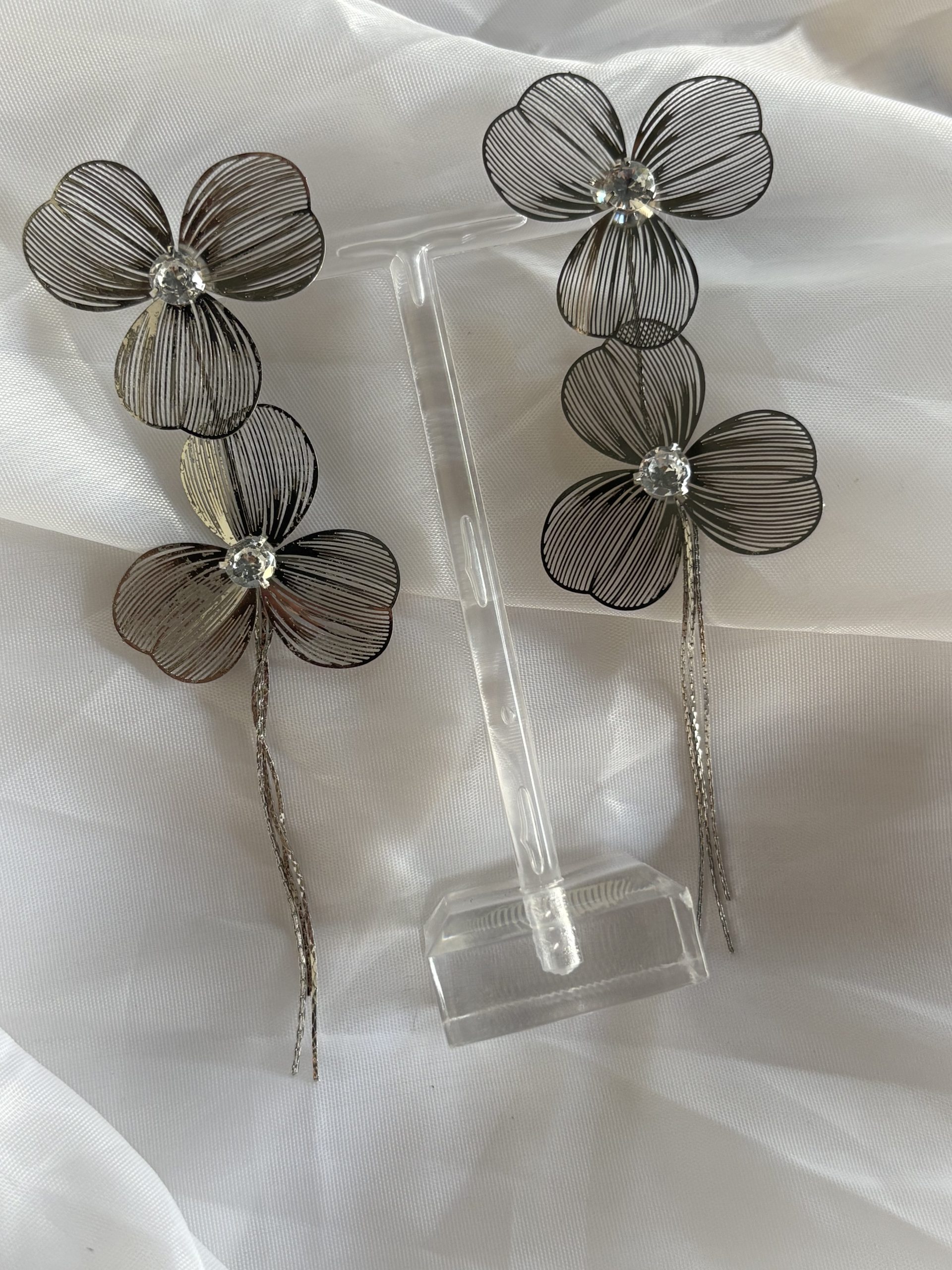 Brinco flor metálica com strass.