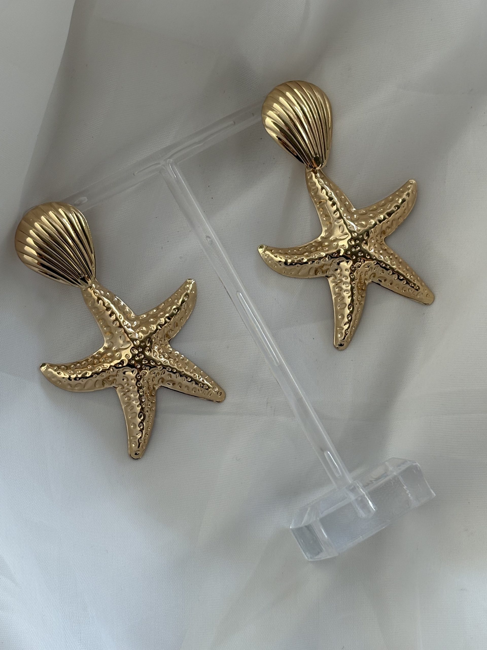 Brinco estrela do mar dourada.