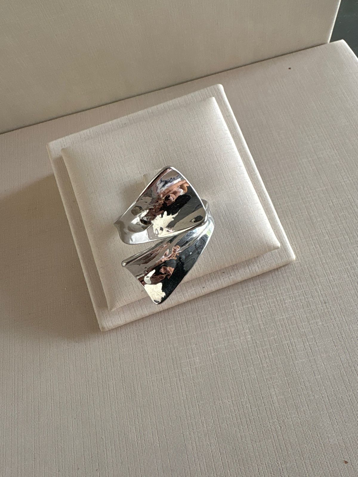 Anel escultural na cor prata.