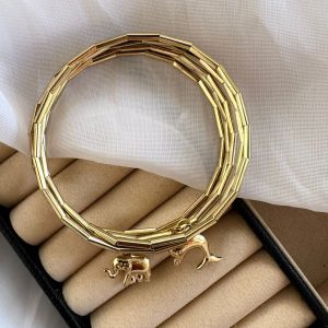 Pulseira dourada com pingentes de elefante e golfinho.
