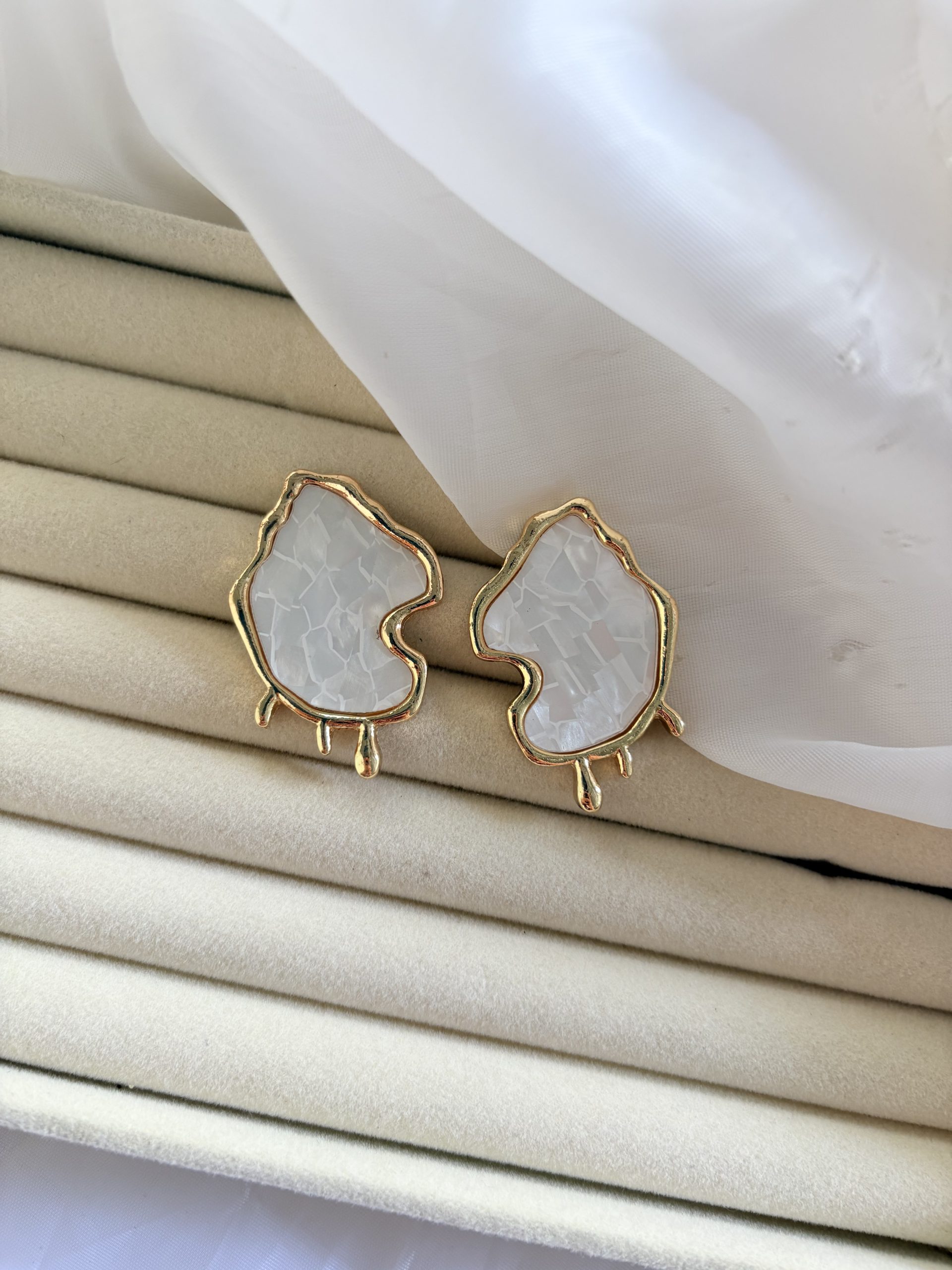 Brinco com design orgânico em acabamento dourado.